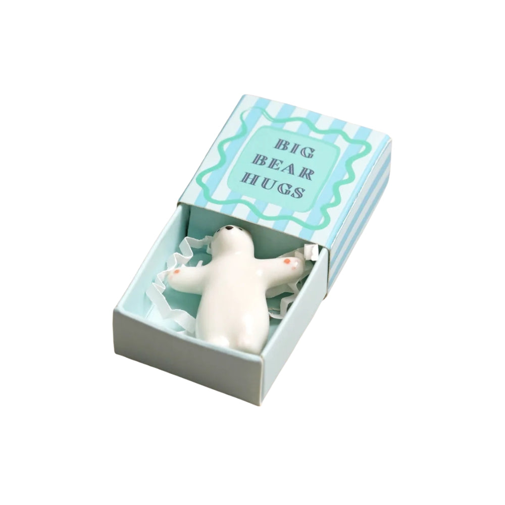 A white bear-shaped squeeze hug toy nestled inside its light blue and white striped gift box, which features the text 'BIG BEAR HUGS' on the lid.