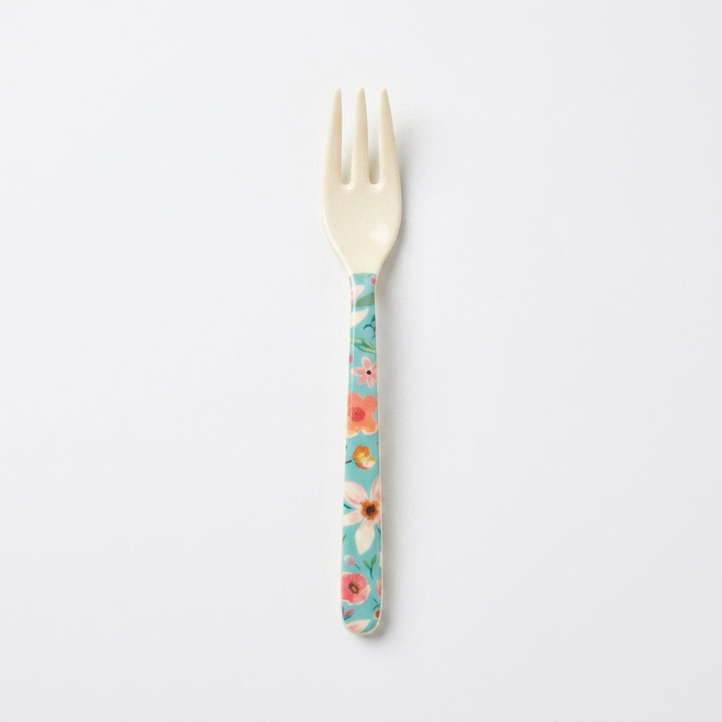 A small plastic fork with a cream-colored head and a handle decorated with a colorful floral pattern on a light blue background, shown against a plain white background.