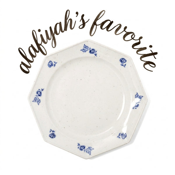 An octagonal white ceramic plate with blue floral patterns around the rim, shown on a white background with the text 'alafiyah's favorite' written in brown script above it.