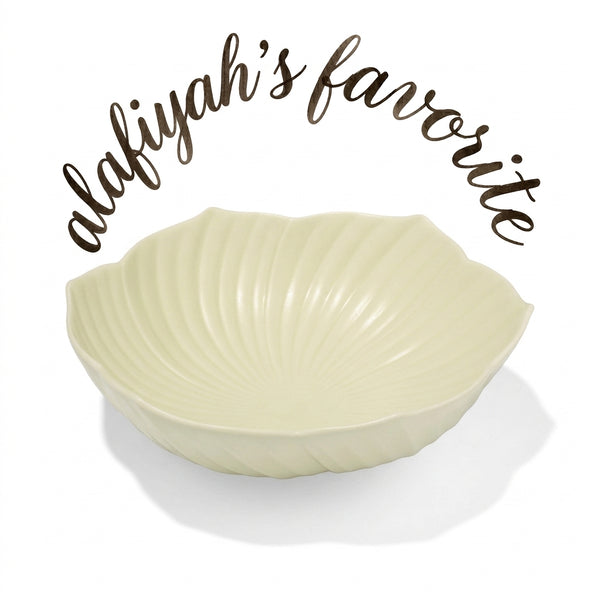 A cream-colored ceramic bowl with a ribbed, petal-like fluted rim, shown on a white background with the text 'alafiyah's favorite' written in brown script above it.