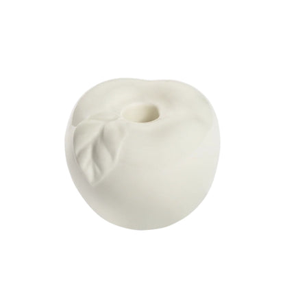White ceramic apple-shaped candle holder with leaf detail, empty, on white background.