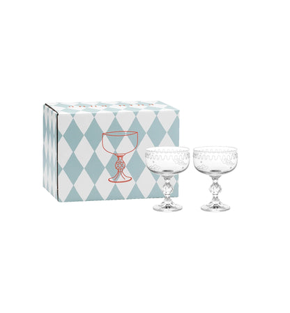 Two crystal glasses in front of a patterned box on a white background.