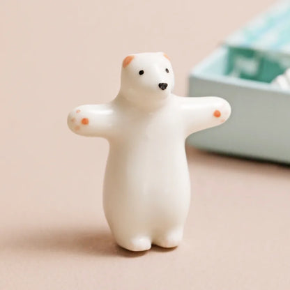Small white polar bear figurine on a beige surface with a blurred background