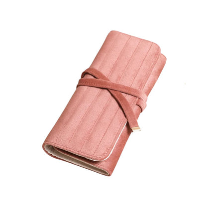 A rolled-up dusty rose pink notebook or journal with a matching wrap-around strap, shown on a plain white background.
