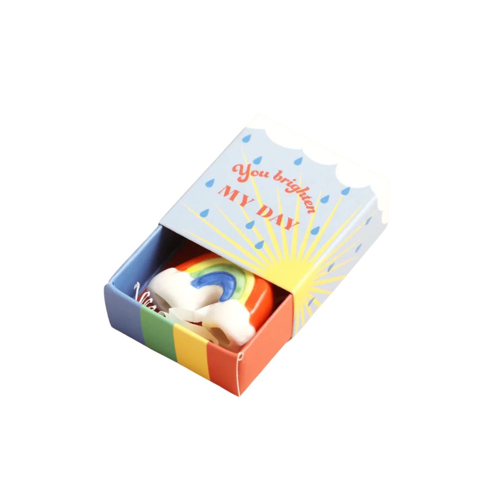 A small gift matchbox with a rainbow and the words 'You brighten MY DAY' on the lid, shown open with a small white and rainbow-themed item inside, photographed on a plain white background.