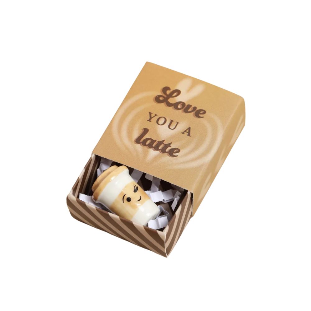 A miniature coffee-themed gift matchbox with a lid printed with 'Love YOU A latte' and a small latte-shaped figurine peeking out from inside on a white background.
