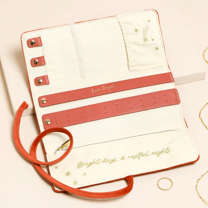 White planner with coral straps and decorative text on a light pink background