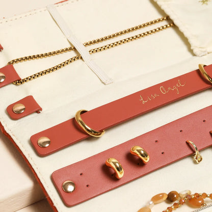 Red leather bracelets with gold accents on a beige surface
