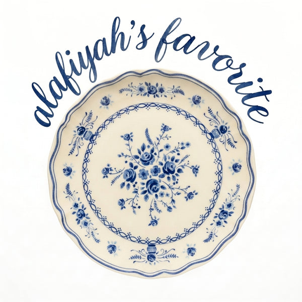 A round ceramic plate with a blue floral pattern on an off-white background, featuring the text 'alafiyah's favorite' in blue script above it, set against a plain white background.