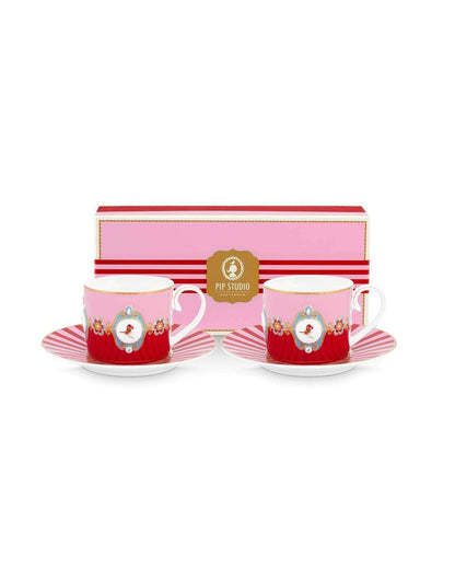 Set of two red ceramic cups with saucers and a pink striped box on a white background